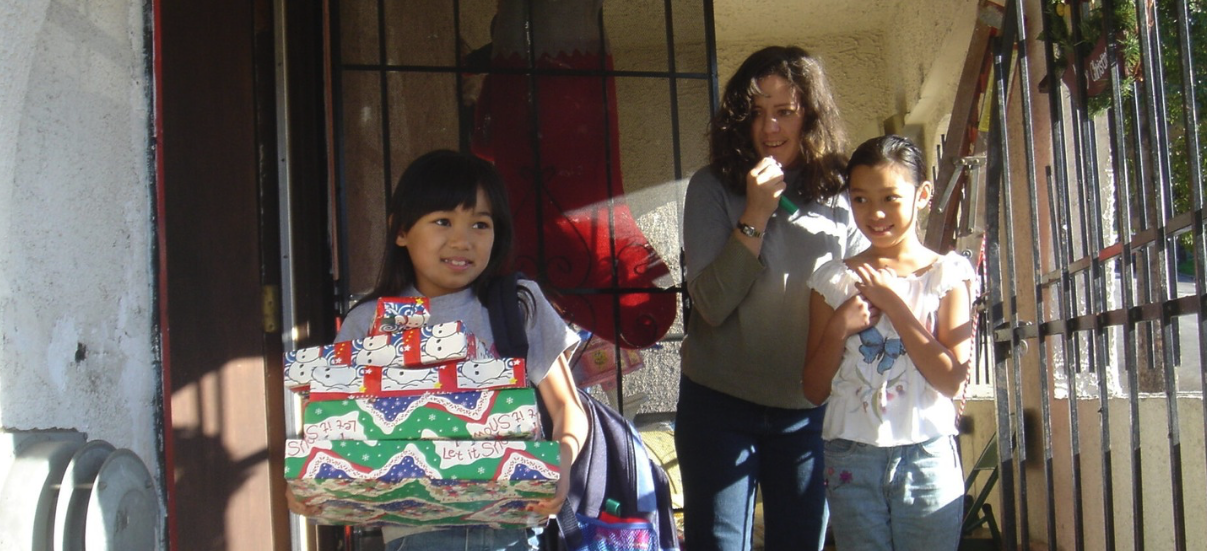 donate gifts to children little girl with Christmas presents usps operation Santa